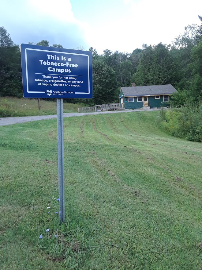 A sign is shown next to a road that states “This is a Tobacco-Free Campus”